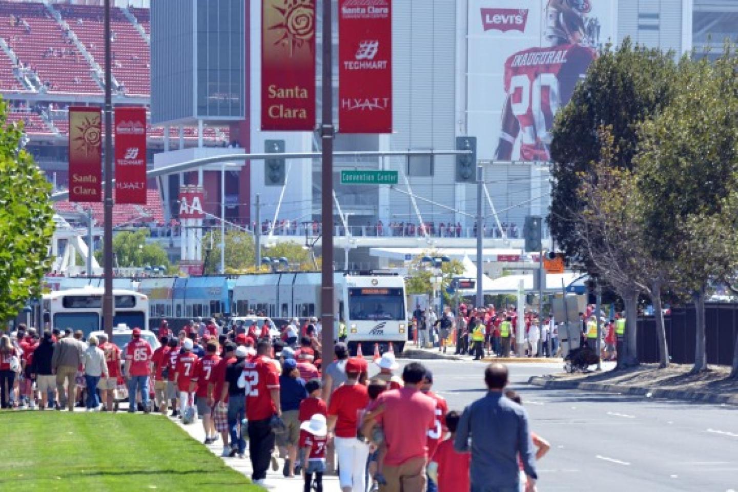 People walking with Levi's Stadium in the background